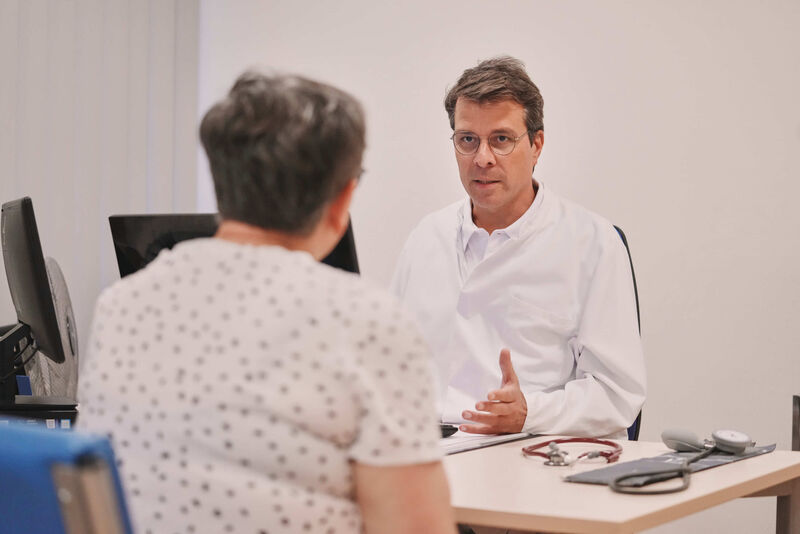 Das Bild zeigt einen Arzt im Gespräch mit einer Patientin.