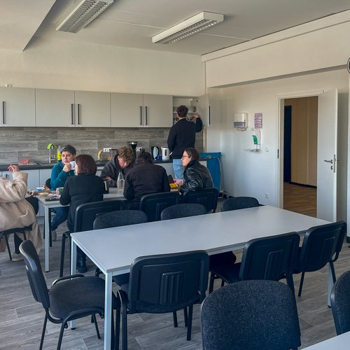 Auszubildende machen in der Gemeinschaftsküche Pause.