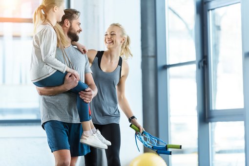 Foto einer glücklichen Familie, die im Fitnesscenter zusammensteht.