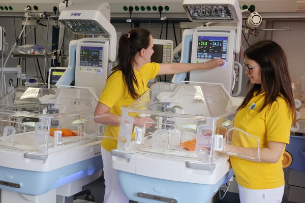 ein moderner Inkubator steht im Neo-Zimmer der Kinderklinik Lauchhammer. Eine Pflegekraft und eine Ärztin bereiten alles vor.