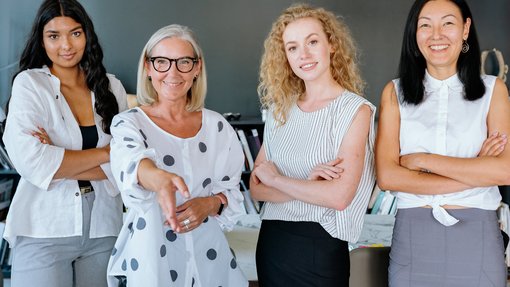 Das Foto zeigt vier Geschäftsfrauen unterschiedlichen Alters. Das Sana Frauennetzwerk EmpowerHer setzt sich für die Stärkung und Förderung von Frauen ein.